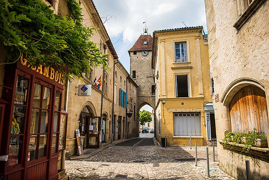 Rue pavée et porte médiévale de la cité fortifiée de Saint-Macaire, près de Bordeaux, idéale pour une escapade en train à moins d’1h.